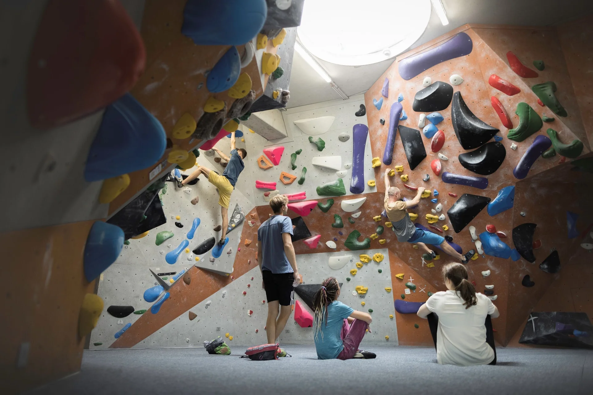 In der Boulderhalle: Ansicht einer Boulderwand mit Sportlern | © DAV / Jens Klatt
