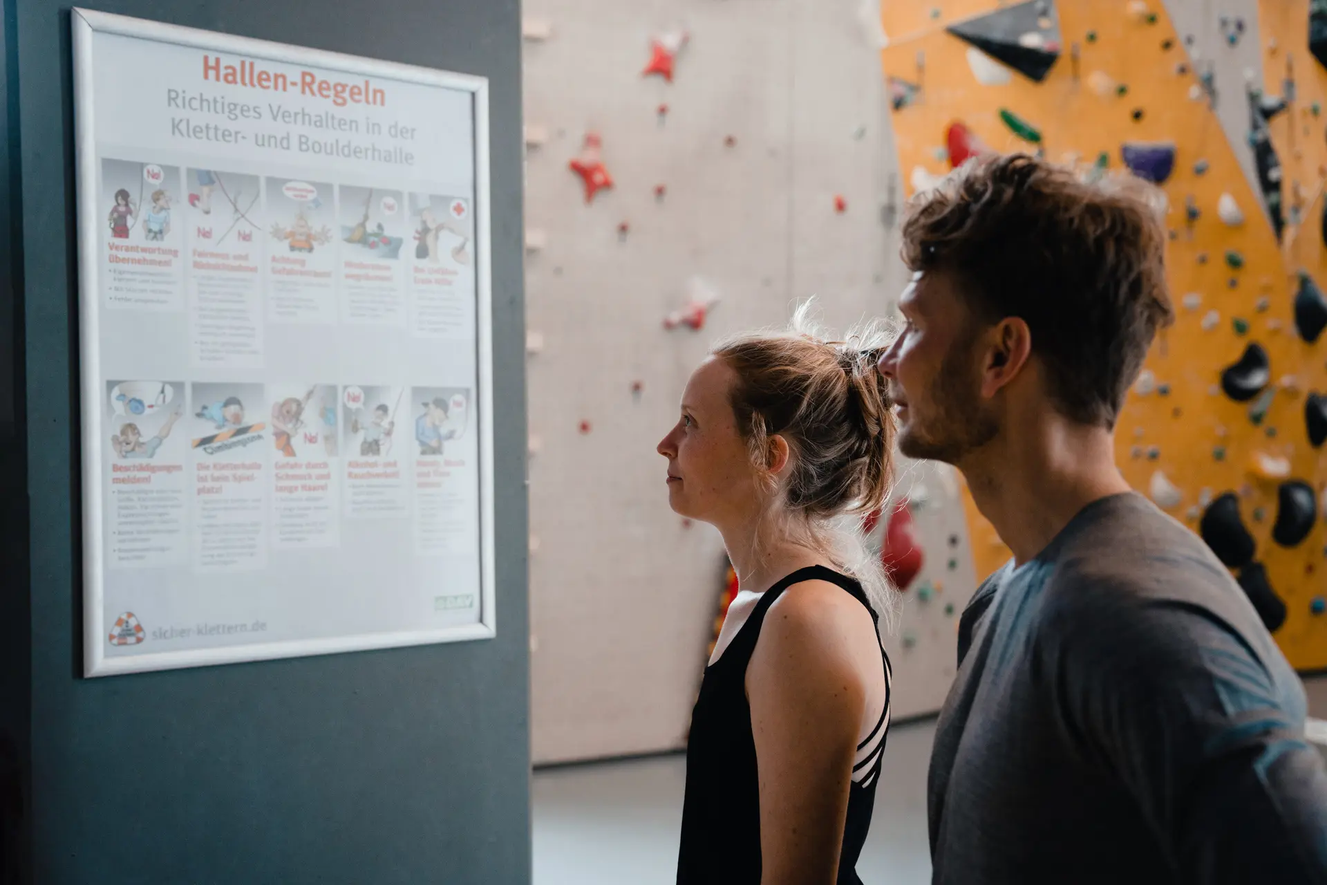 Zwei Personen checken den Trainingsplan, der an einer Wand hängt | © DAV/Marisa Koch