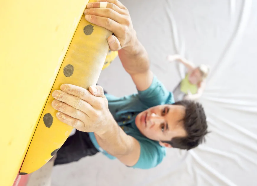 Ein Mann beim Training an einem gelben Campusboard - aus der Vogelperspektive fotografiert | © DAV/ Hansi Heckmair