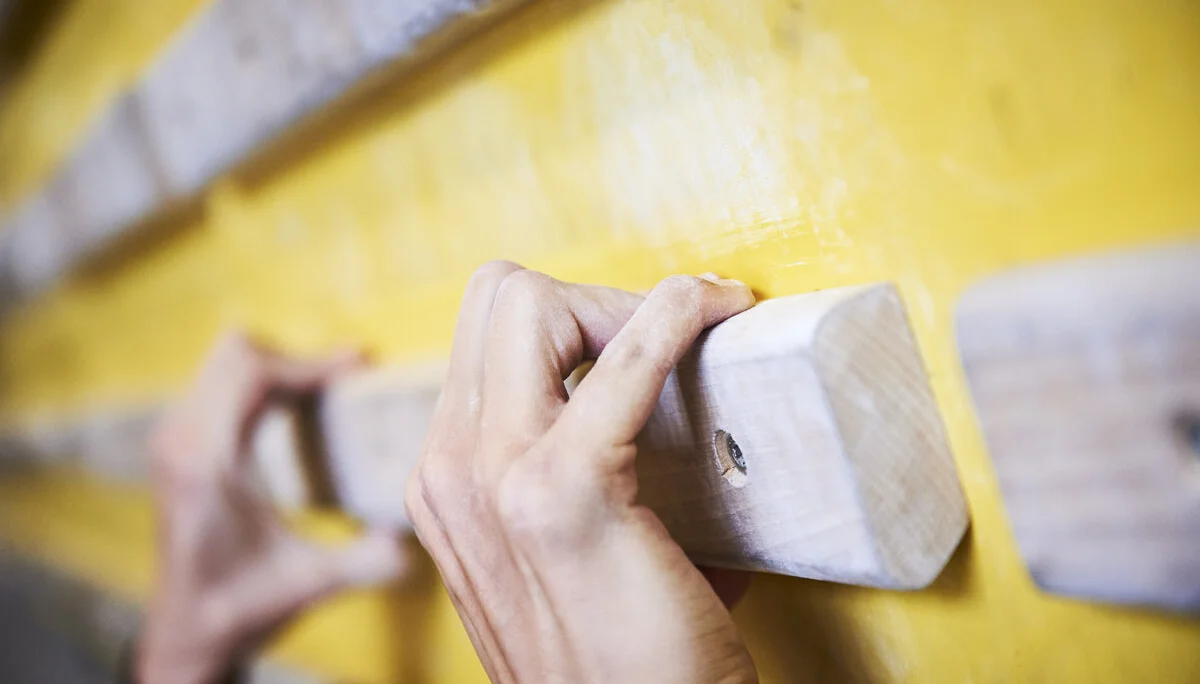 Hände greifen nach Holzelementen an einer Kletterwand | © DAV/Frank Kretschmann