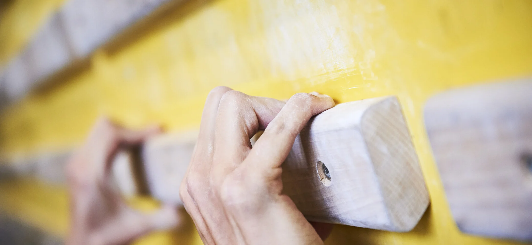 Hände greifen nach Holzelementen an einer Kletterwand | © DAV/Frank Kretschmann