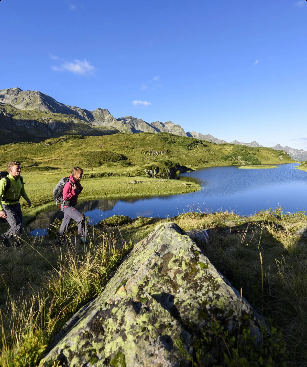 Wanderer im Frühling - im Hintergrund ein Bergsee | © DAV/Wolfgang Ehn