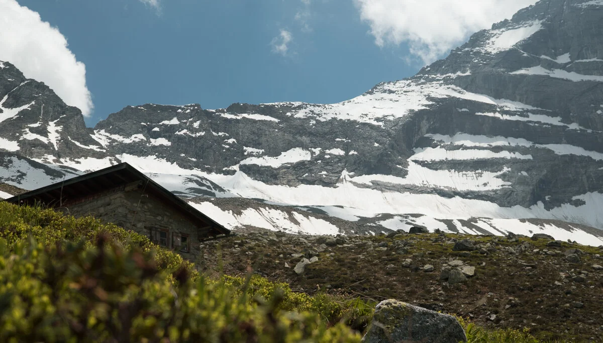 Schneebedeckte Berge, eine Hütte im Vordergrund | © DAV/Marcel Dambon