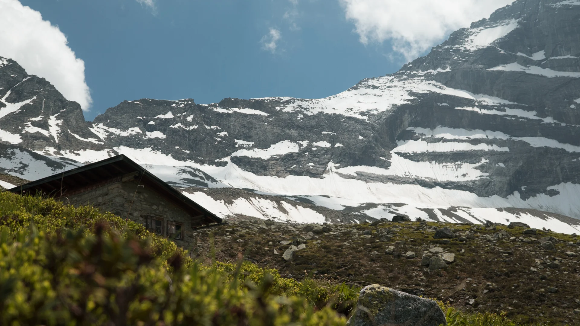 Schneebedeckte Berge, eine Hütte im Vordergrund | © DAV/Marcel Dambon