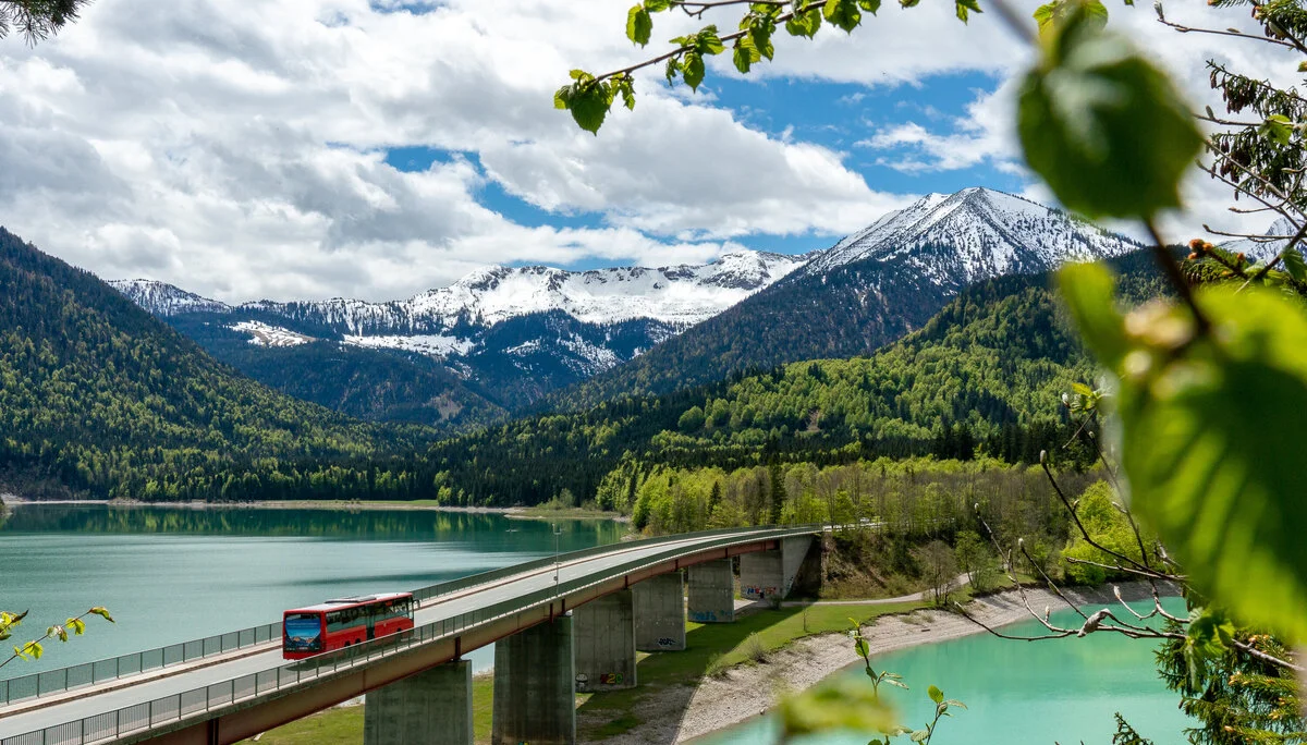 Der Bergbus des Deutschen Alpemvereins fährt über eine Brücke in die Alpen | © DAV/Tobias Hipp